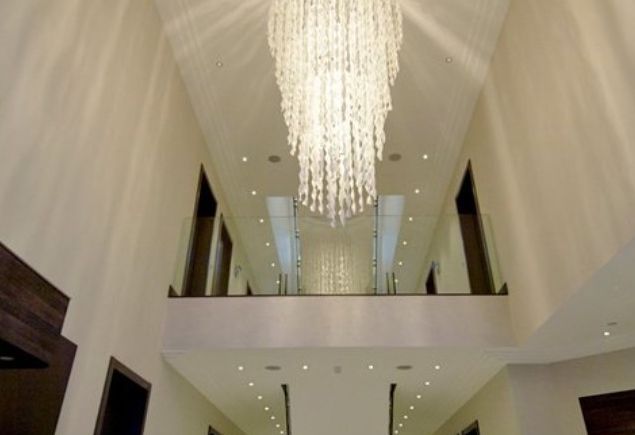 Double-height hallway with crystal chandelier at Ernest Road