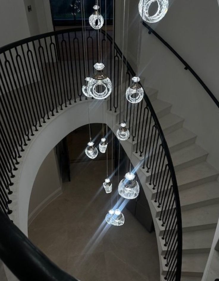 Curved staircase beneath cascading crystal pendants